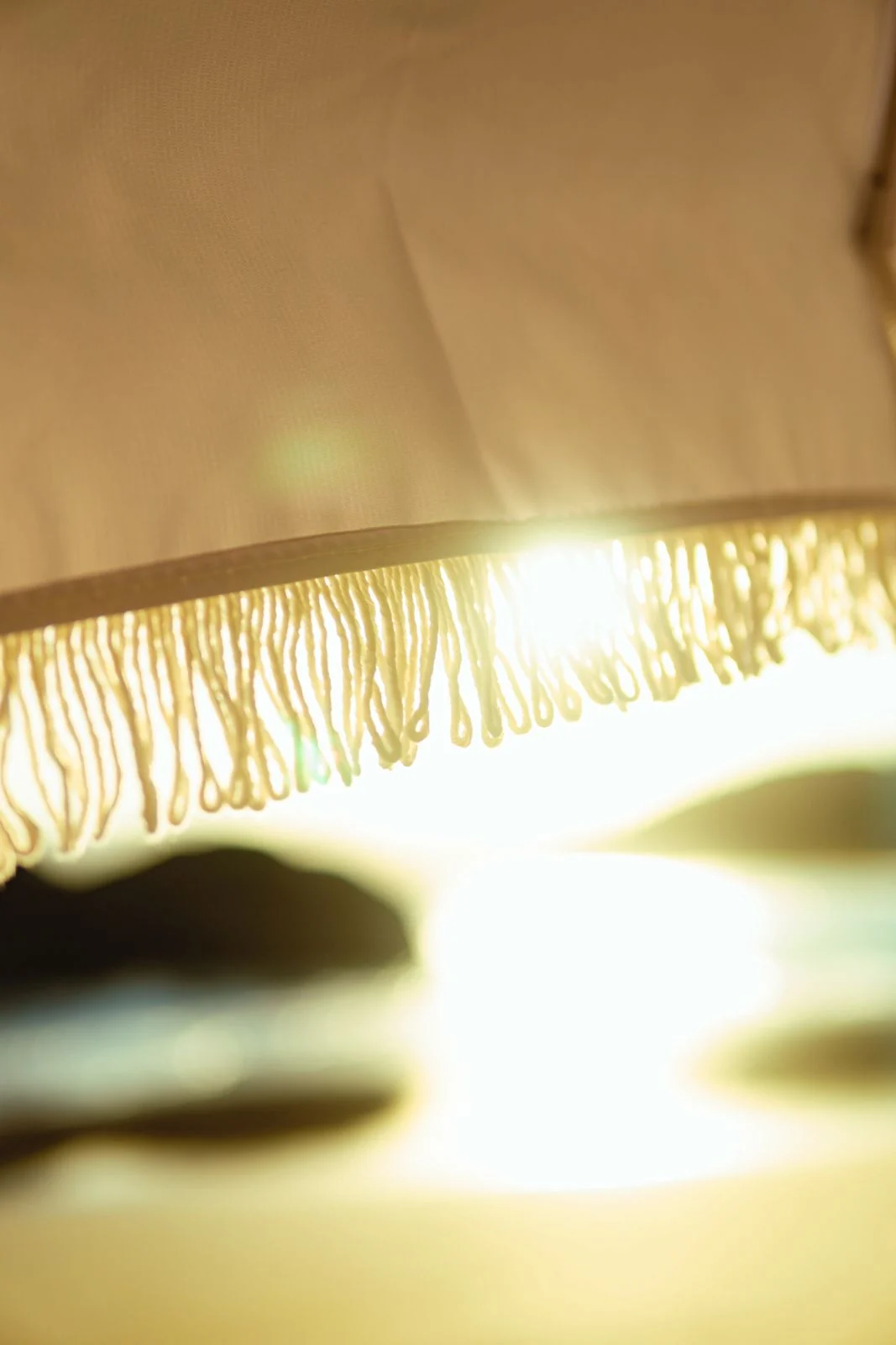 Luz do sol atravessando as franjas de um guarda-sol